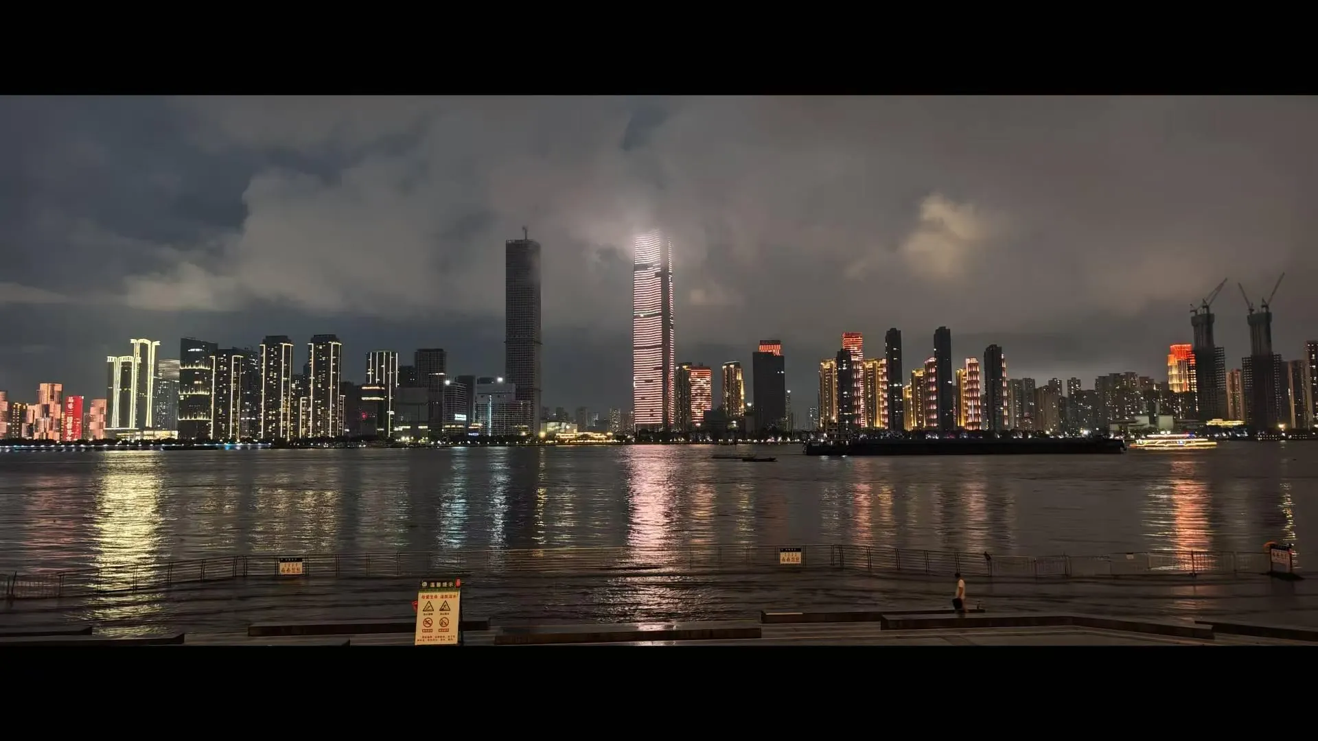 夜色下隔水相望的城市楼群