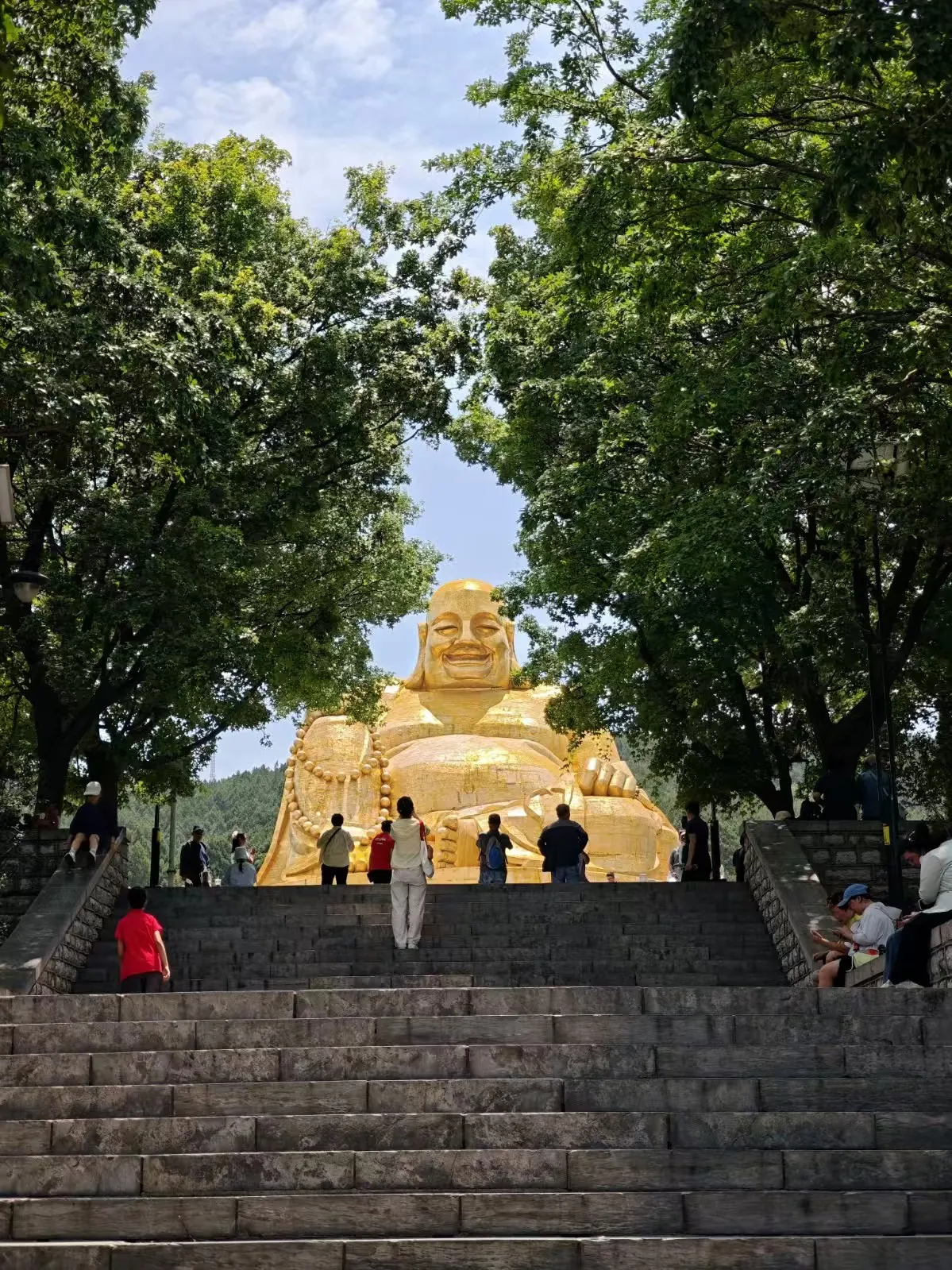 树荫与台阶尽头的金色雕像