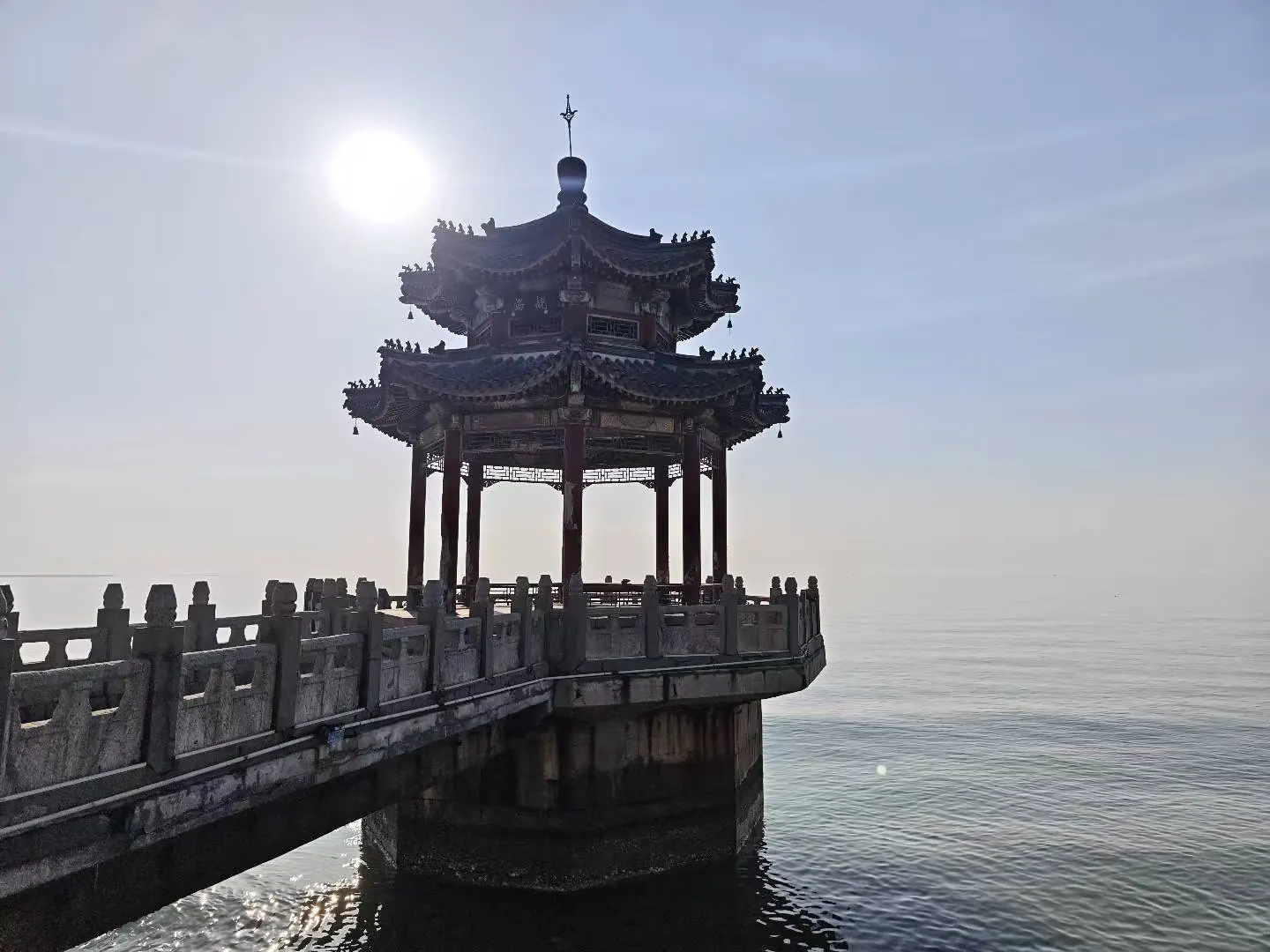 阳光下伸向水面的亭台